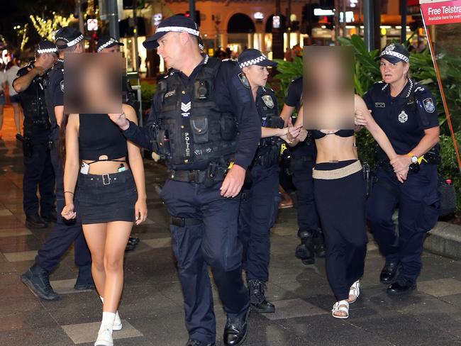 Police in Surfers Paradise 'wanding' revellers for knives. - The female on the right was taken back to the watch house where she stayed overnight for drunkenness 25 March 2023 Surfers Paradise Picture by Richard Gosling