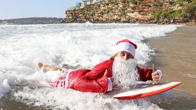 The Harbord Hotel’s Surfing Santa on a wave at Freshwater Beach. Picture: Tim Hunter