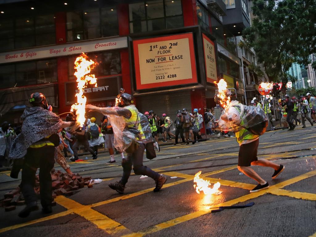 Members of the media run after being hit by flames during clashes with police in Wan Chai, Hong Kong. Picture: AP