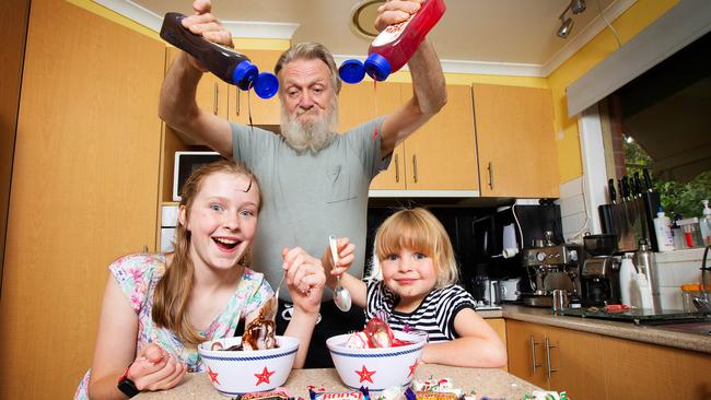 Pakenham grandfather Ian Rowed 71 treats grandchildren Savannah, 11, and Sophia, 5, to some junk food. Picture: Mark Stewart