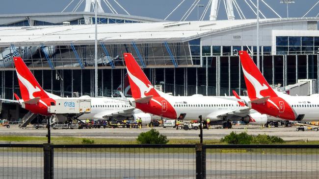 Three Qantas Boeing B737 planes lined up at the domestic terminal of Sydney Kingsford-Smith Airport.  Luggage handlers and other staff are visible on the tarmac.  This image was taken from a pedestrian bridge off Airport Drive, Mascot on a cloudy afternoon on 12 March 2023.Escape 15 October 2023Doc Holliday - Airports ExtraPicture : iStock