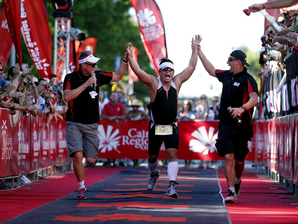 Ironman officials help Aruto Cruz crossing the line in the Urban Hotel Group Ironman 70.3 Cairns.