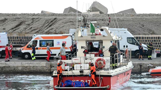 Divers of the Vigili del Fuoco, the Italian Corps. of Firefighters arrive in Porticello harbour near Palermo, with a body bag at the back of the boat on August 22, three days after the British-flagged luxury yacht Bayesian sank. Picture: Alberto Pizzoli/AFP