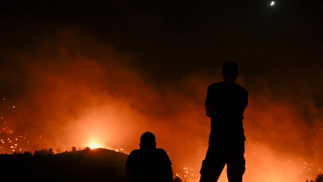 People watch the fires near the village of Malona in the Greek island of Rhodes. Picture: AFP.