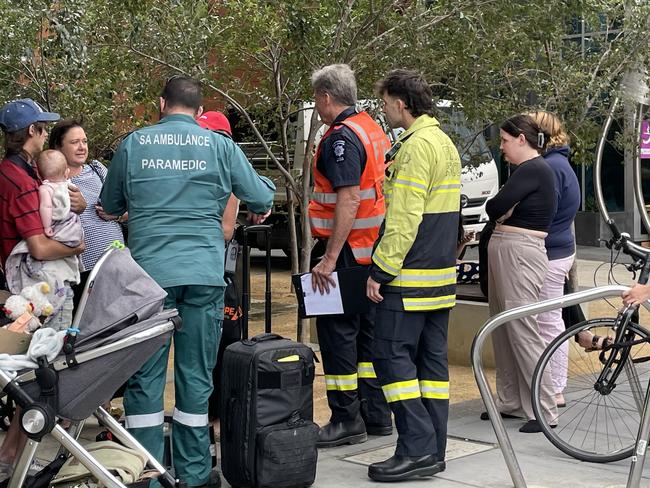 People with prams and pets wait outside the Waymouth St apartment block. Picture: Dylan Hogarth