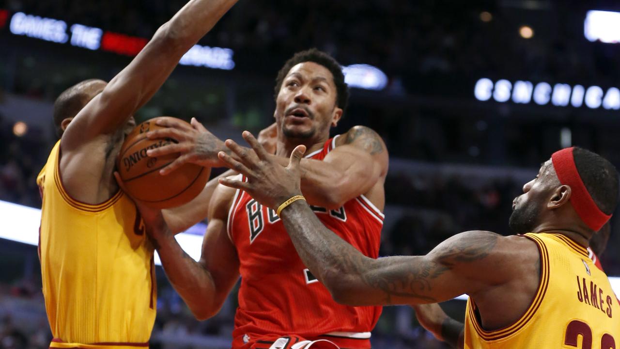 Chicago Bulls guard Derrick Rose (1) drives and scores past Cleveland Cavaliers' James Jones, left, and LeBron James during the second half of an NBA basketball game Thursday, Feb. 12, 2015, in Chicago. The Bulls won 113-98. (AP Photo/Charles Rex Arbogast)