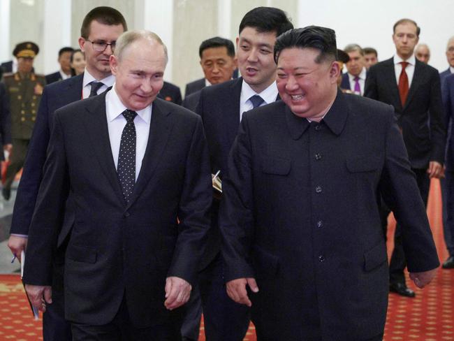 Vladimir Putin and Kim Jong-un share a lighter moment during a gala concert in Pyongyang. Picture: AFP