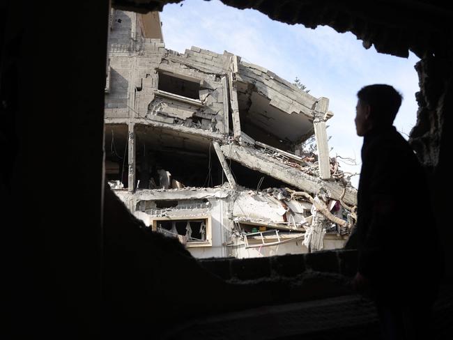 A Palestinian youth looks through a damaged building's window onto the destruction following overnight Israeli strikes on a residential area in Jabalia's southwestern district of Nazla in the northern Gaza Strip. Picture: AFP