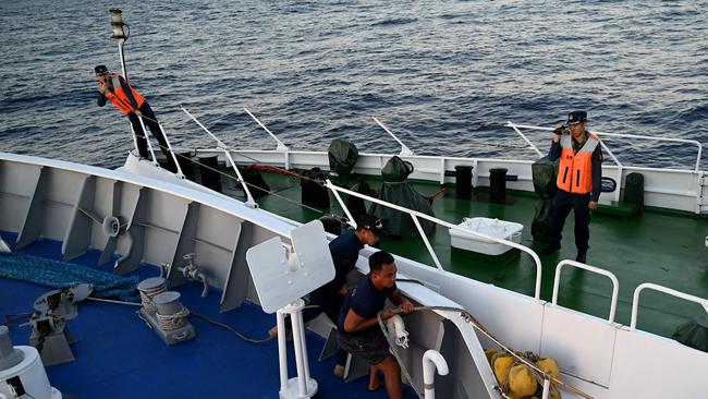 Philippine Coast Guard personnel holding the fender during a minor collision between the BRP Sindangan, left, and a China Coast Guard vessel in March. Picture: AFP