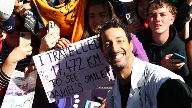 Daniel Ricciardo of Australia with a fan holding a banner on the Melbourne Walk prior to practice. Picture: Peter Fox/Getty Images