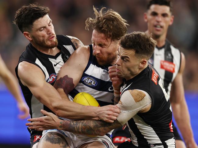 MELBOURNE, AUSTRALIA - Augus 11 , 2023. AFL .      Zach Tuohy of the Cats gets tackled by Jamie Elliott and Jack Crisp of the Magpies during the round 22 match between Collingwood and Geelong at the MCG in Melbourne.   Photo by Michael Klein.
