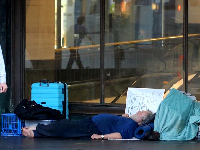 Workers pass homeless people on their way to work on Tuesday morning. Picture: John Grainger