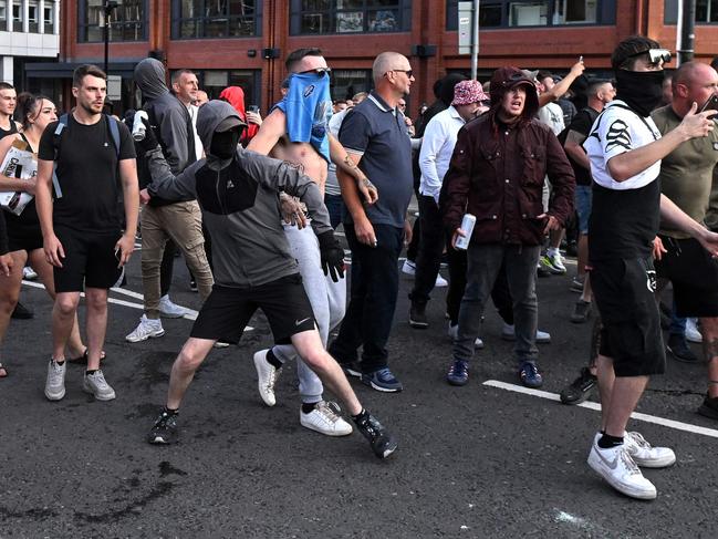 A masked protester throws a can of beer towards riot police in Bristol. Picture: AFP