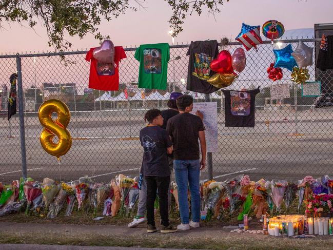 High school friends who attended the Travis Scott concert sign a remembrance board at a makeshift memorial at the NRG Park grounds. Picture: AFP