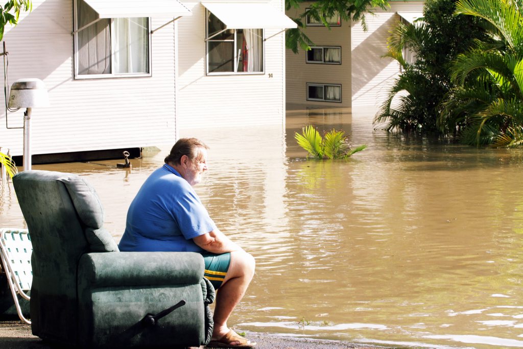 Wallace Caravan Park resident Heinz Quint, 73, looks on as an excavator moves units to higher ground. Picture: Robyne Cuerel