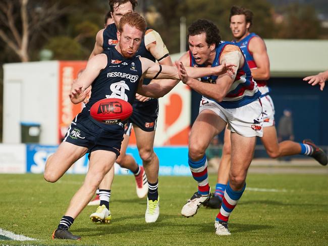 South's Nicholas Liddle gets a kick off before being tackled by Central's Darcy Fort at Noarlunga Oval in Noarlunga Downs, in the SANFL match between South Adelaide and Central District, Saturday, May 5, 2018. (AAP Image/MATT LOXTON)