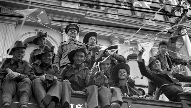 Soldiers and locals clamber to get a better view of the Victory Parade on Queen St, Brisbane, in August 1945.