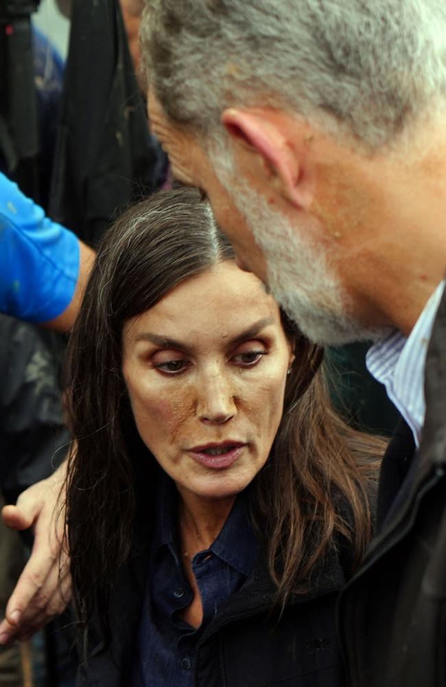 Queen Letizia of Spain, with mud stains on her face, talks with King Felipe VI during their visit to Paiporta. Picture: AFP