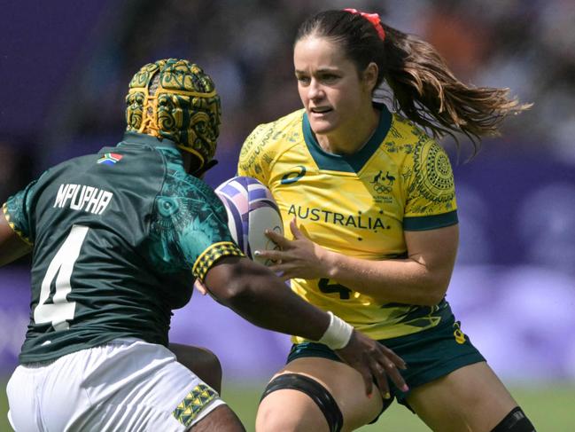 Australia's Dominique Du Toit (R) is chased by South Africa's Zintle Mpupha (L) during the women's pool B rugby sevens match between Australia and South Africa during the Paris 2024 Olympic Games at the Stade de France in Saint-Denis on July 28, 2024. (Photo by CARL DE SOUZA / AFP)