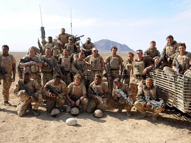 Prince Harry (5th right) poses with soldiers in the desert on February 19, 2008 in Helmand Province, Afghanistan. Picture: John Stillwell