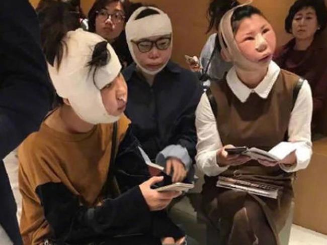 The women — wrapped chin-to-dome in bandages — were barred from boarding a flight home at an airport in South Korea. Picture: Asiawire/Australscope