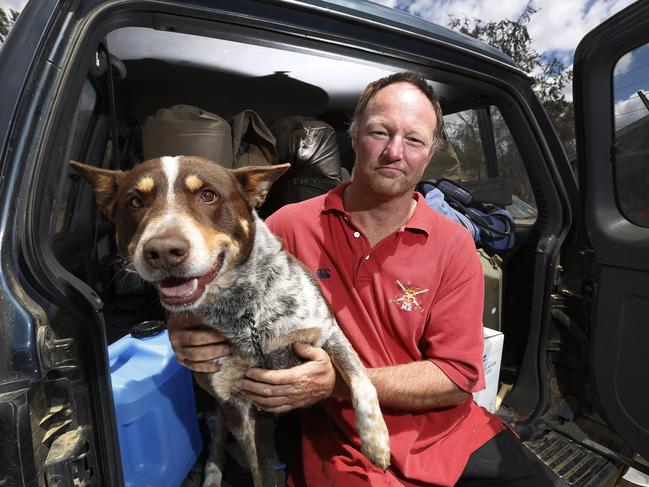 Darren Neale with family dog Sapper outside the Broadmarsh Community Hall. The family fled their Bluff Rd home yesterday afternoon as fires threatened the area. Picture: ZAK SIMMONDS