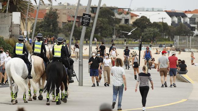 Mounted police patrol St Kilda beach after hundreds flocked to the area during warm weather over the weekend. Picture: Daniel Pockett