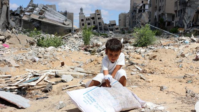 A Palestinian boy plays with sand in front of buildings heavily damaged in Israeli bombing, in Beit Lahia in the northern Gaza Strip on September 14, 2024. Picture: Omar Al-Qattaa/AFP