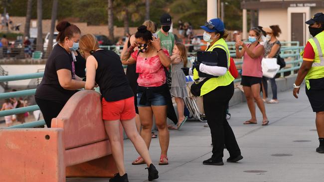 A city employee reminds people to wear face masks in Manhattan Beach, California, amid the coronavirus pandemic. Picture: AFP