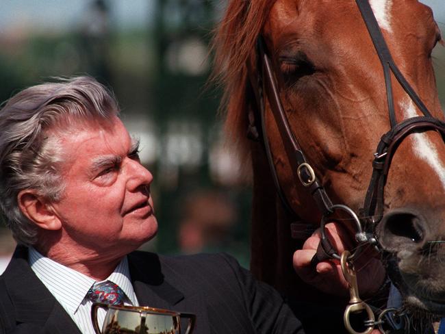 Racehorse trainer Bart Cummings holding bridle of 1996 Melbourne Cup winner Saintly.