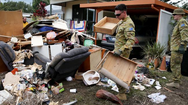 Defence Force members help remove debris in the aftermath of the flood. Picture: Nathan Edwards