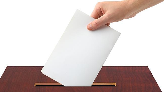 Thinkstock generic image of hand voting, putting piece of white paper into ballot box.