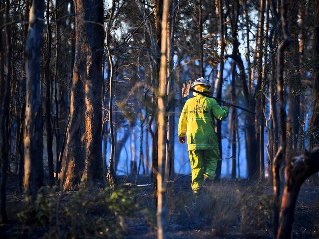 A firefighter checks the area of the fire. A fast moving grass fire has caused two main highways west of Brisbane to close on Saturday afternoon. Saturday September 26, 2020. Picture John Gass