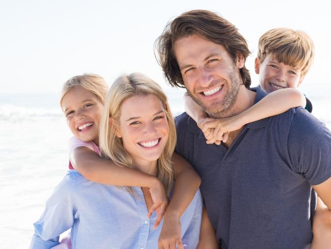 Parents giving piggyback ride to kids at beach. Close up of smiling family having fun at summer vacation. Portrait of happy family, generic