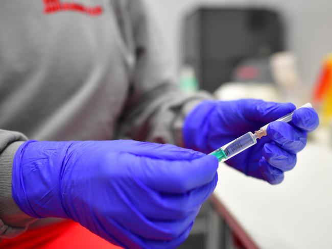 OSNABRUECK, GERMANY - DECEMBER 13: A medical worker of the Johanniter, a Protestant aid organization, holds a syringe filled with saline solution during a test run at a future Covid-19 vaccine center on December 13, 2020 in Osnabrueck, Germany. Across Germany event arenas, trade fair halls, gymnasiums and other venues are being converted into vaccine centers, with many beginning test runs ahead of approval by European Union health authorities of the new vaccine. The first real inoculations could begin by the end of December. (Photo by Alexander Koerner/Getty Images)