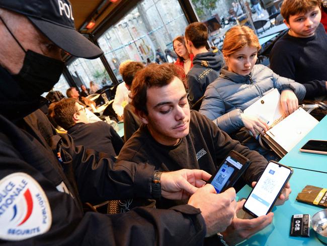 A police officer checks health passes in a bar in Saint-Malo, France. Picture: Jean-FrancoisMonier/AFP