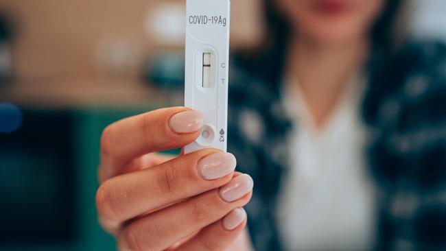 Close-up shot of woman's hand holding a negative test device. Young woman showing her negative Coronavirus/Covid-19 rapid test. Focus is on the test. Picture: istock/VioletaStoimenova