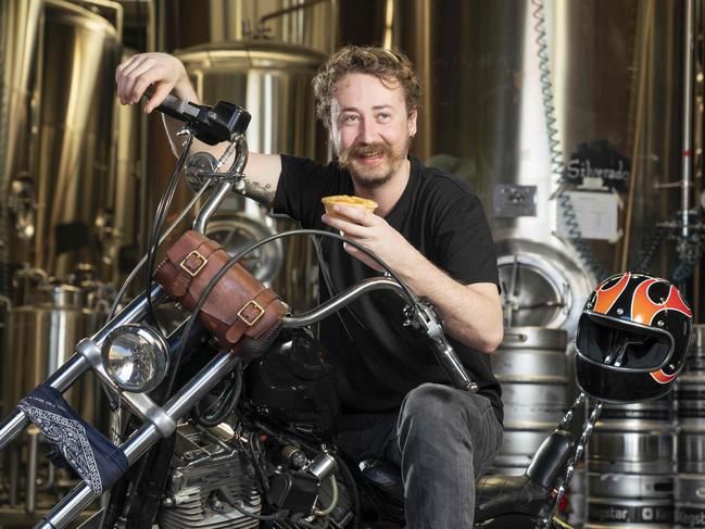 Young Henrys and Harry’s Cafe de Wheels have joined forces to create a meat pie inspired by Young Henry’s Hoppy Porter Motorcycle Oil beer. Head brewer Jesse Searls was keen to try one before Sunday’s 100 pie giveaway. Picture: Matthew Vasilescu