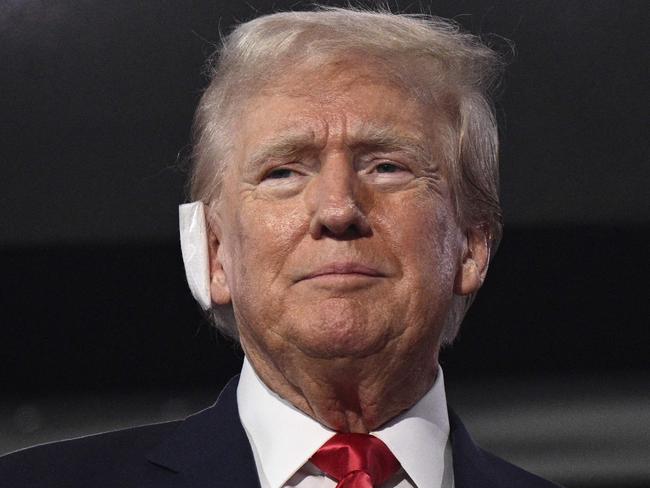 US former President and 2024 Republican presidential candidate Donald Trump, a bandage on his ear after being wounded in an assassination attempt, attends the first day of the 2024 Republican National Convention at the Fiserv Forum in Milwaukee, Wisconsin, July 15, 2024. Donald Trump won formal nomination as the Republican presidential candidate and picked a right-wing loyalist for running mate, kicking off a triumphalist party convention in the wake of last weekend's failed assassination attempt. (Photo by Brendan SMIALOWSKI / AFP)