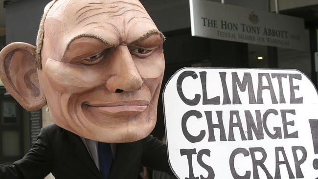 A demonstrator with a giant head in the likeness of former Australian Prime Minister Tony Abbott holds a sign referencing a comment by Abbott made in 2017 belittling the science of climate change. Picture: Rick Rycroft