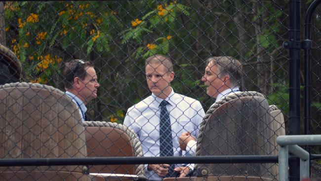 Police detectives are seen behind one of the rafts from the Thunder River Rapids ride at the Dreamworld on November 1, 2016.