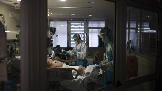 Healthcare workers assist a COVID-19 patient at an intensive care units at German Trias i Pujol hospital in Barcelona, Spain. Picture: AP