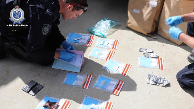 Strike Force Sulfur officers inspecting items seized during raids across Queanbeyan and Canberra in September. Picture: NSW Police