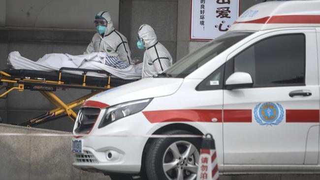 Medical staff transfer patients to Jin Yintan hospital in Wuhan, in January last year. Picture: Getty Images