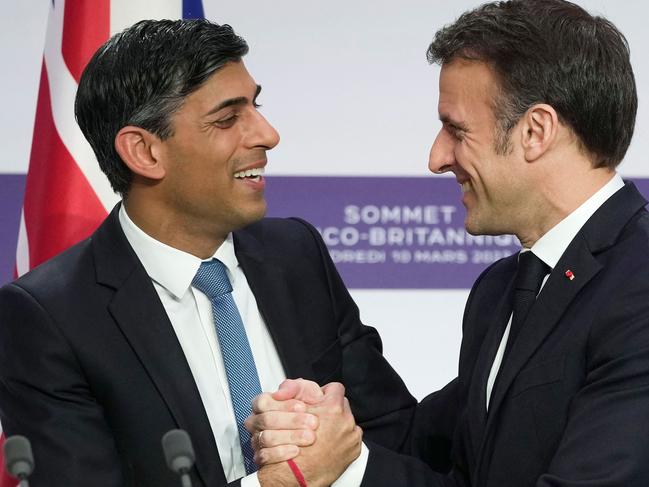 TOPSHOT - Britain's Prime Minister Rishi Sunak (L) and France's President Emmanuel Macron (L) react as they shake hands during a joint press conference at the end of the French-British summit, at the Elysee Palace, in Paris, on March 10, 2023 - British Prime Minister Rishi Sunak and French President Emmanuel Macron agreed a new pact to stop illegal cross-Channel migration after a summit in Paris on March 10, 2023 aimed at overcoming years of Brexit tensions. Both leaders hailed a new start in relations between the two neighbours, after intense talks in Paris which were also marked by expressions of unity in their support for Ukraine in fighting the Russian invasion. (Photo by Kin Cheung / POOL / AFP)