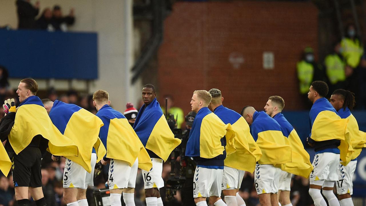 Everton players line up wearing the Ukrainian flag. Photo by Oli SCARFF / AFP.