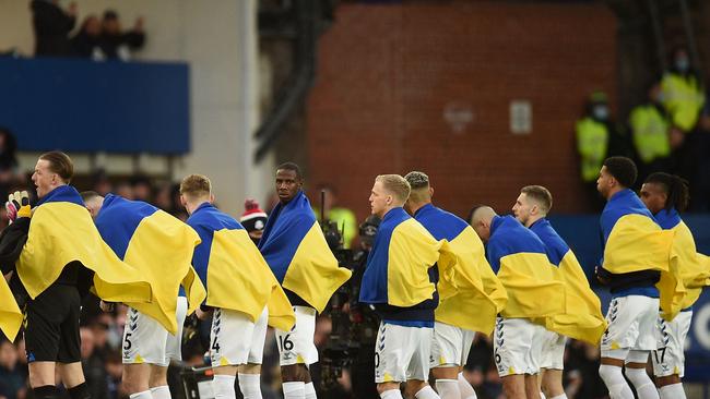 Everton players line up wearing the Ukrainian flag. Photo by Oli SCARFF / AFP.