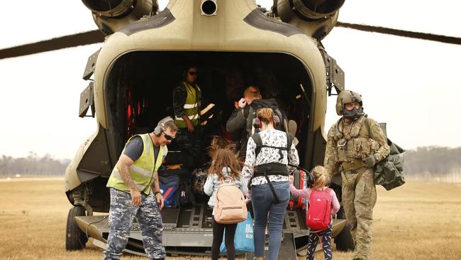 Evacuees are flown out of Mallacoota Airport by Army chinook helicopters bound for Sale. Picture: David Caird