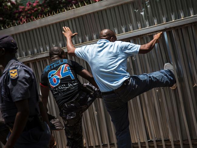 Congolese protesters kick the gate of the Democratic Republic of the Congo embassy in Pretoria, South Africa. Picture: AFP/John Wessels