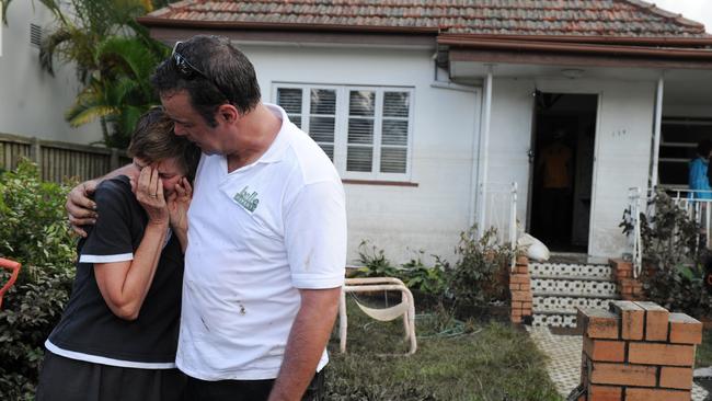 An emotional Jacky Greenwood was comforted by Jason Amos outside her mother’s home as neighbours helped with the clean up of the flood damage in Rosalie, Brisbane on Friday, Jan. 14, 2011.